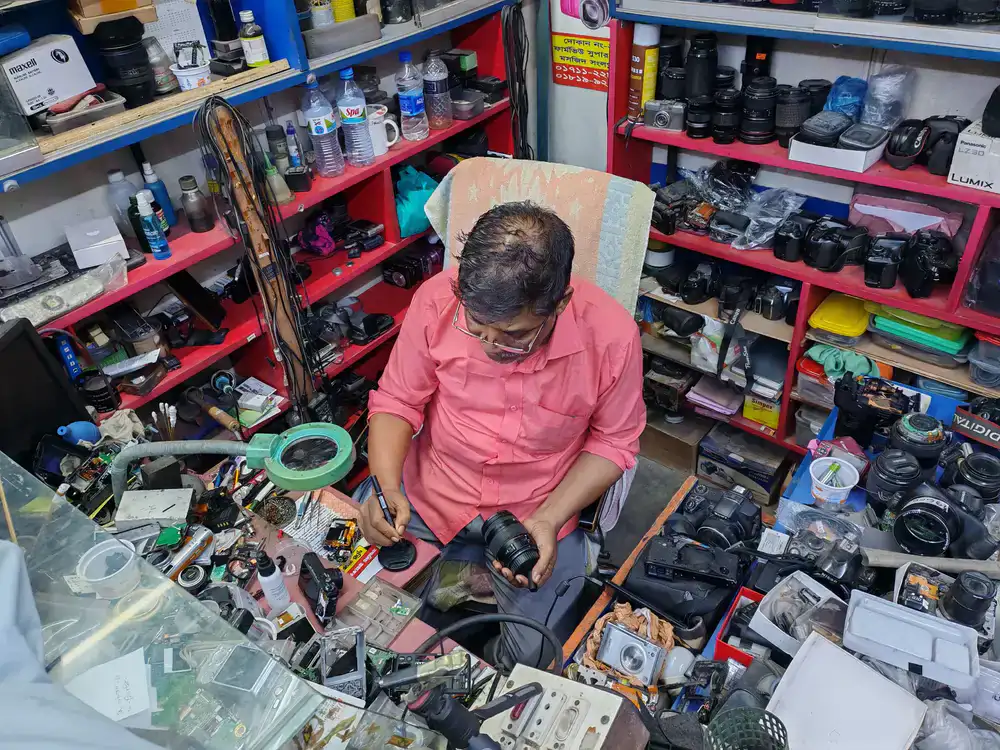 Technician working on a camera body with specialized tools