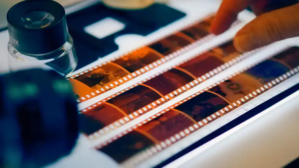 Close up of a film negative being scanned on a glowing light bed